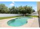 Private backyard featuring a sparkling pool, mature trees, and a pristine white fence for added privacy at 11845 Newberry Grove Loop, Riverview, FL 33579