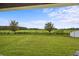 Expansive backyard view featuring a vast green field and trees at 11871 Crestridge Loop, Trinity, FL 34655