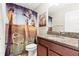 Bathroom showcasing a unique art-themed shower curtain and granite countertop at 11871 Crestridge Loop, Trinity, FL 34655
