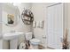 Neutral bathroom with a pedestal sink, round mirror, and a toilet at 11871 Crestridge Loop, Trinity, FL 34655