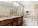 Bathroom featuring double granite vanity, soaking tub, and tiled shower at 11871 Crestridge Loop, Trinity, FL 34655