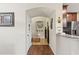 Hallway leading to the kitchen featuring hardwood flooring and neutral walls at 11871 Crestridge Loop, Trinity, FL 34655