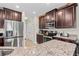 Kitchen with dark cabinetry, granite countertops, stainless steel appliances including a refrigerator and oven at 11871 Crestridge Loop, Trinity, FL 34655