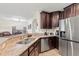 Well-equipped kitchen with granite countertops, stainless steel refrigerator, and dark wood cabinets at 11871 Crestridge Loop, Trinity, FL 34655