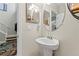 Simple powder room with pedestal sink and decorative mirror at 11871 Crestridge Loop, Trinity, FL 34655