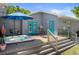 Relaxing backyard featuring a hot tub, dining set, and colorful turquoise doors leading to the home's interior at 1209 W Adalee St, Tampa, FL 33603