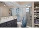 Well-lit bathroom featuring a modern vanity, toilet, decorative shower curtain, and tiled walk-in shower at 1209 W Adalee St, Tampa, FL 33603