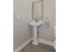 Charming powder room featuring a classic pedestal sink and decorative mirror at 1209 W Adalee St, Tampa, FL 33603