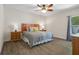 Bright bedroom featuring a ceiling fan, wood floors, and decoratively pillowed king size bed at 1209 W Adalee St, Tampa, FL 33603