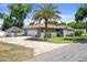Exterior shot of a home featuring a spacious driveway, garage, and mature palm tree at 1209 W Adalee St, Tampa, FL 33603