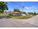Charming gray home with manicured lawn, inviting deck, and mature palm trees at 1209 W Adalee St, Tampa, FL 33603