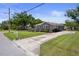 Charming gray home with a long driveway, manicured lawn, and inviting front deck at 1209 W Adalee St, Tampa, FL 33603