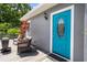 Charming front porch seating area with stylish blue door and beautiful landscaping accents at 1209 W Adalee St, Tampa, FL 33603