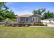 Cozy home featuring a front deck, lovely landscaping, and a quaint blue front door at 1209 W Adalee St, Tampa, FL 33603