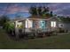 Charming home boasts a inviting front deck, complemented by well-manicured landscaping and a vibrant blue front door at 1209 W Adalee St, Tampa, FL 33603