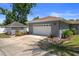View of the detached garage and driveway, showcasing landscaping, exterior lighting, and yard at 1209 W Adalee St, Tampa, FL 33603