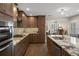 Open kitchen has stainless appliances, granite counters, and wood cabinets at 1209 W Adalee St, Tampa, FL 33603