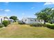 A nice backyard view of the home with manicured lawn and shade tree at 12501 Ulmerton Rd # 89, Largo, FL 33774