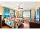 Comfortable bedroom with warm-toned walls, wood floors, and a large floral-patterned bedspread at 12501 Ulmerton Rd # 89, Largo, FL 33774