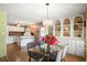 Charming dining room features a glass table, built-in display cabinets, and wood laminate floors at 12501 Ulmerton Rd # 89, Largo, FL 33774