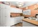 Functional kitchen with white cabinetry, updated countertops, and vinyl wood floors at 12501 Ulmerton Rd # 89, Largo, FL 33774