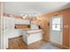 Efficient kitchen features white cabinetry, breakfast bar, and vinyl floors at 12501 Ulmerton Rd # 89, Largo, FL 33774