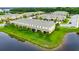 A long aerial view showcases a sprawling townhome community with lush greenery and a tranquil pond at 12952 Utopia Gardens Way, Riverview, FL 33579