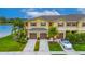 Aerial view of townhomes near a pond, featuring well-maintained lawns and car parked in driveway at 12952 Utopia Gardens Way, Riverview, FL 33579