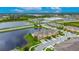 An aerial view of townhomes located beside a serene lake, complemented by lush greenery and a clear blue sky at 12952 Utopia Gardens Way, Riverview, FL 33579