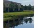 Beautiful backyard view of the two-story home with a tranquil pond and lush green landscaping at 12952 Utopia Gardens Way, Riverview, FL 33579