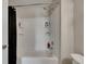 Clean, white tub-shower combination with toiletries and a black shower curtain at 12952 Utopia Gardens Way, Riverview, FL 33579