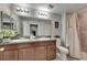 Bathroom with double sink vanity, granite countertop, and tiled shower at 12952 Utopia Gardens Way, Riverview, FL 33579
