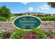 The Summerfield Crossings entrance sign with stone base and colorful flowers welcomes residents and guests at 12952 Utopia Gardens Way, Riverview, FL 33579
