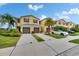 Inviting exteriors with two-car garages, brown shutters, mature landscaping, and ample parking at 12952 Utopia Gardens Way, Riverview, FL 33579