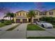 Charming townhome exterior features manicured landscaping, palm trees, and private driveways with garage at 12952 Utopia Gardens Way, Riverview, FL 33579
