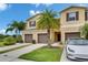 A townhome with brown shutters, a garage and a well manicured green lawn with palm trees at 12952 Utopia Gardens Way, Riverview, FL 33579