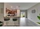 An open living space boasts an island with seating, tile floor, and a view to the lake at 12952 Utopia Gardens Way, Riverview, FL 33579