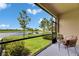 Tranquil screened-in patio overlooking a serene lake with lush landscaping at 12952 Utopia Gardens Way, Riverview, FL 33579