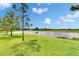 Picturesque view of the lush green lawn leading to the pond at 12952 Utopia Gardens Way, Riverview, FL 33579