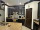 Well-equipped kitchen with granite countertops, dark cabinets, and stainless steel appliances at 13172 Green Violet Dr, Riverview, FL 33579