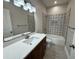 Bathroom featuring a tub with decorative tile surround, quartz countertops and dark wood cabinets at 13532 14Th St, Dade City, FL 33525