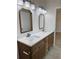 Bathroom vanity featuring double sinks, chrome fixtures, wood cabinets and two decorative mirrors at 13532 14Th St, Dade City, FL 33525