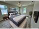 A virtually staged bedroom featuring a large bed, hardwood floors, large windows, and neutral colors, creating a cozy atmosphere at 13532 14Th St, Dade City, FL 33525