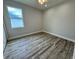 Bright bedroom featuring fresh paint, a window and attractive laminate flooring at 13532 14Th St, Dade City, FL 33525