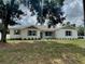 Beautiful one-story home with white painted brick, green trim and shutters and attractive front yard landscaping at 13532 14Th St, Dade City, FL 33525