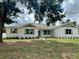 Beautiful one-story home with white painted brick, green trim and shutters and attractive front yard landscaping at 13532 14Th St, Dade City, FL 33525
