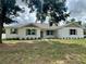 Beautiful one-story home with white painted brick, green trim and shutters and attractive front yard landscaping at 13532 14Th St, Dade City, FL 33525