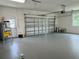 Spacious garage with painted floor, storage space, and functional door at 13532 14Th St, Dade City, FL 33525
