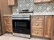 Stainless steel oven with wooden cabinets and decorative backsplash in this modern kitchen at 13532 14Th St, Dade City, FL 33525