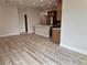 An open concept living room with grey floors leading to the kitchen at 13532 14Th St, Dade City, FL 33525
